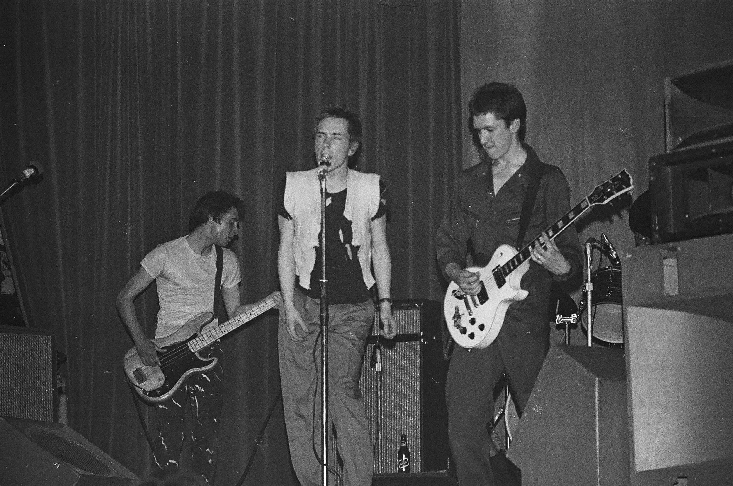 The Sex Pistols at the Manchester’s Lesser Free Trade Hall, June 4, 1976. (left to right) Bassist Glen Matlock, singer Johnny Rotten, and guitarist Steve Jones. Photo by Paul Welsh/Redferns.